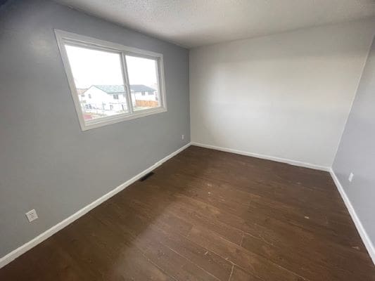 Empty room with wooden floor and window.