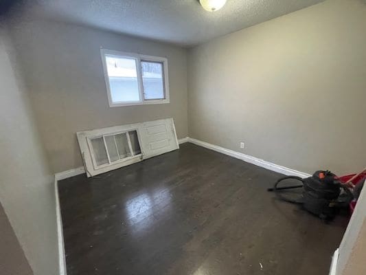 Empty room with dark wooden floor.