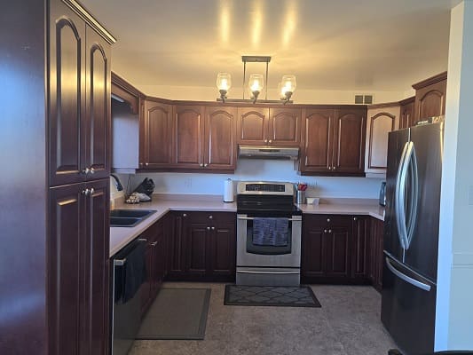 Modern kitchen with wooden cabinets and appliances.