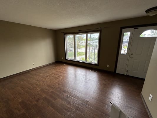 Empty room with wooden floor and window.