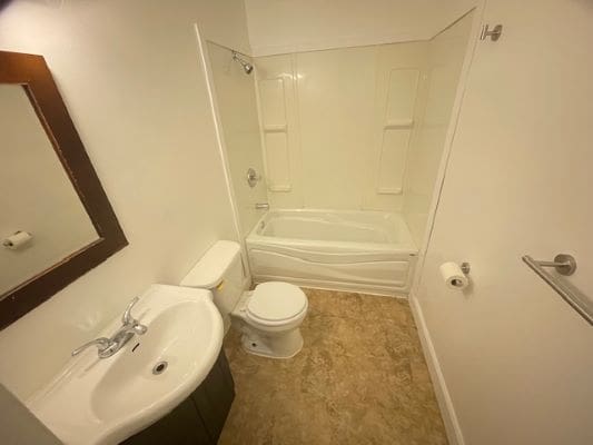 Small bathroom with sink, toilet, and bathtub.