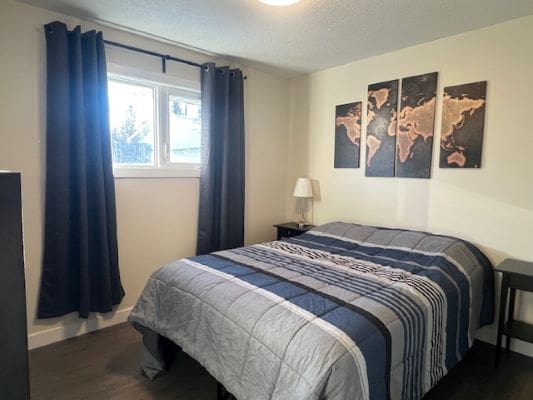 Bedroom with striped bedding and world map.
