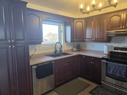 Wooden kitchen cabinets with stainless steel appliances.
