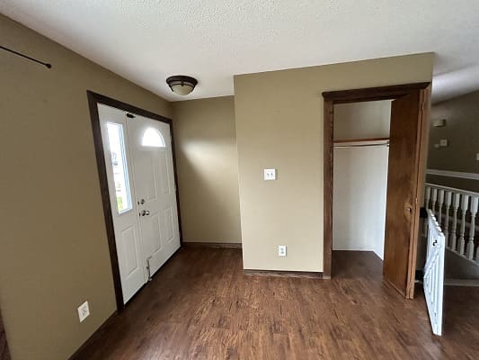 Room with wooden floor and front door.
