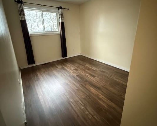Empty room with wooden floor and window.