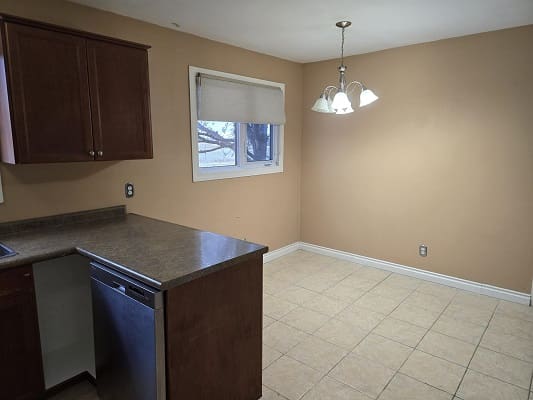 Kitchen with brown cabinets and tiled floor.