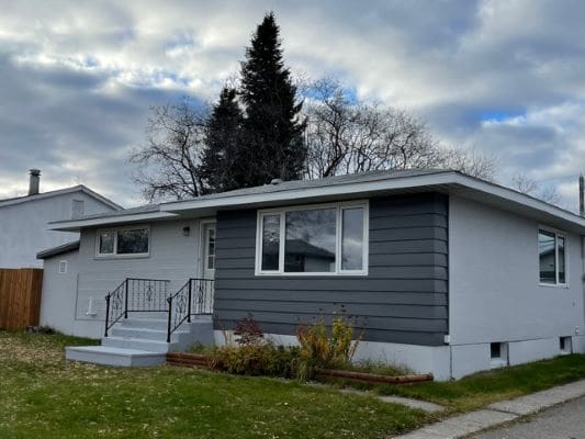 Single-story house with gray siding.