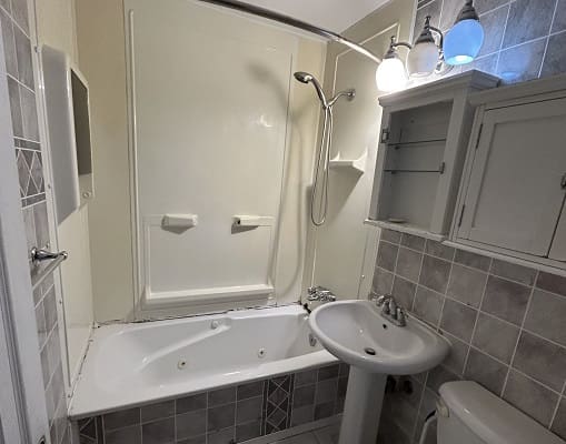 Small bathroom with bathtub and sink.