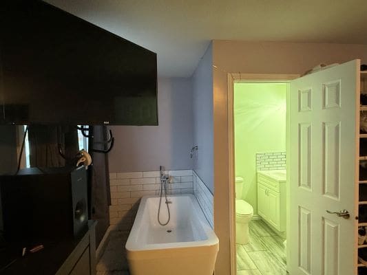 Bathroom with freestanding tub and open door.
