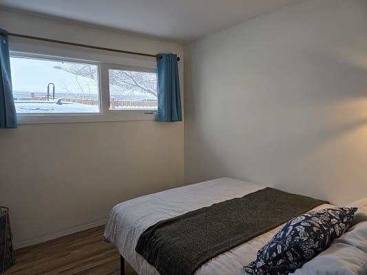 Small bedroom with bed and window view.