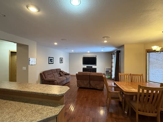 Open living room with sofas and dining table.