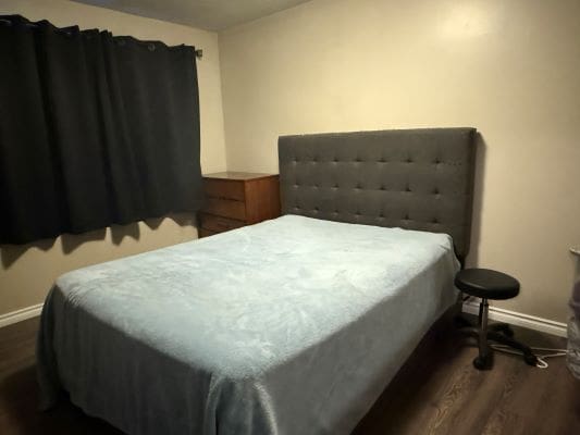 Bedroom with bed, nightstand, and curtains.