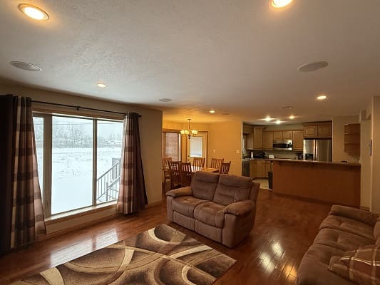 Cozy living room and kitchen with snow view.