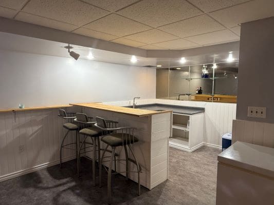 Home basement bar with stools and counter.