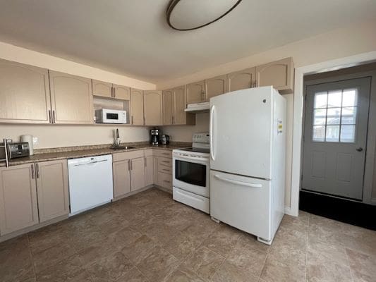 Modern kitchen with appliances and tiled floor.