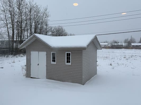 Small shed in snowy landscape.