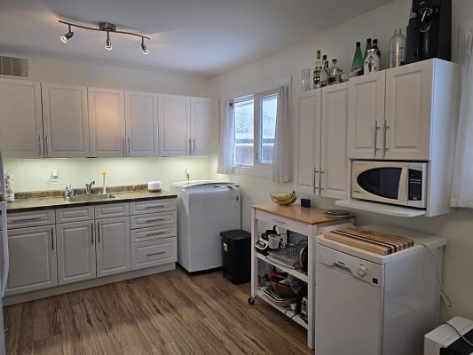 Modern kitchen with white cabinets and appliances.