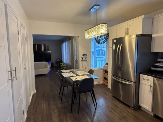 Modern kitchen and dining area with lighting.