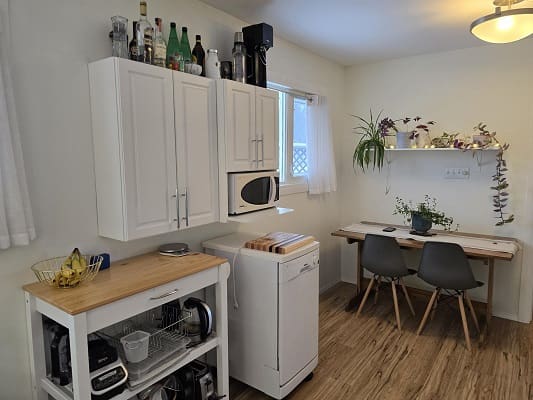 Small kitchen with table and white cabinets.