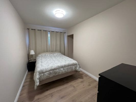 Small bedroom with bed and dresser.