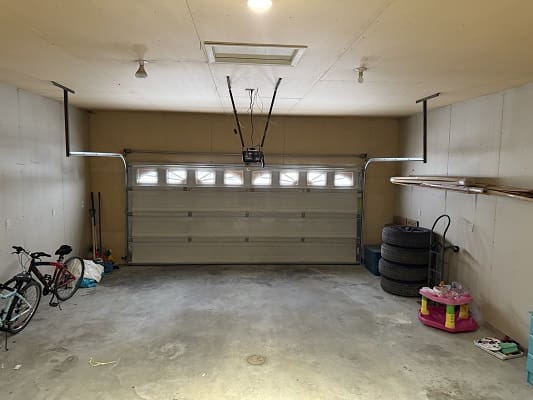 Empty garage with bicycle and stored items.