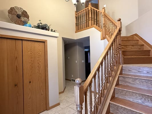 Wooden staircase and hallway with closet doors.