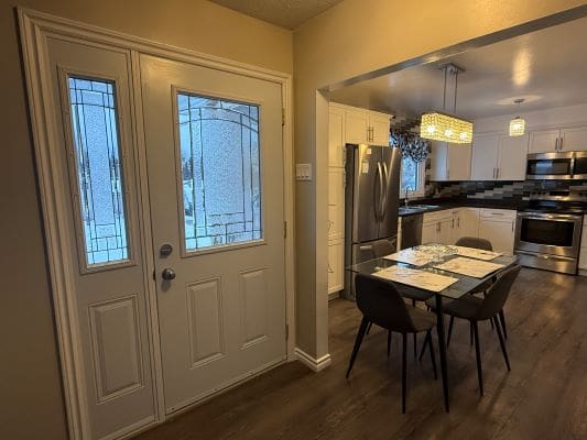 Modern kitchen and dining area with door.