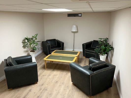 Four black chairs in a minimalist room.