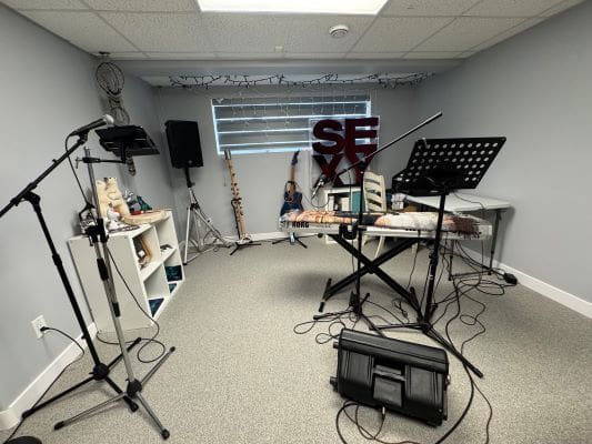 Music studio with instruments and microphone stands.