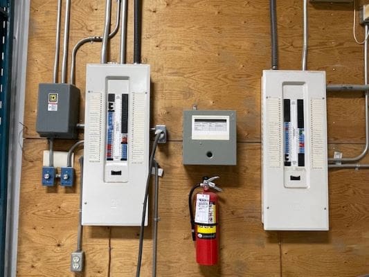 Electrical panels and fire extinguisher on wall.