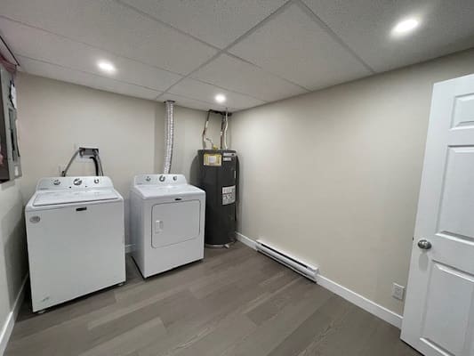 Laundry room with washer, dryer, and heater.