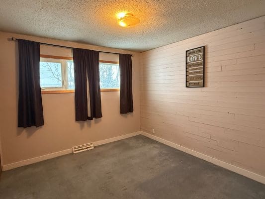 Empty room with carpet and wall art.