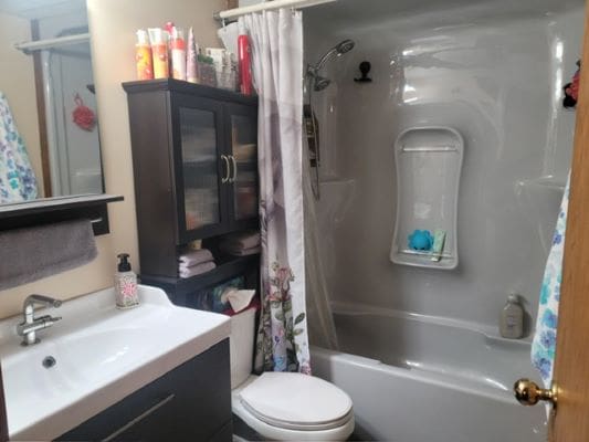 Modern bathroom with shower and storage cabinet.