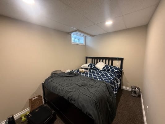 Small bedroom with bed and minimal decor.