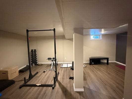 Home gym with weights and exercise equipment.