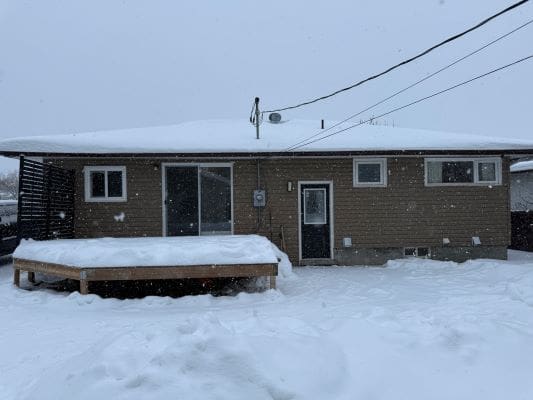 House in snowy backyard setting.