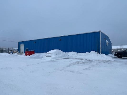 Blue building in snowy parking lot.