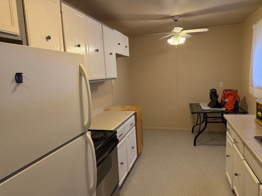 Simple kitchen with white cabinets and appliances.
