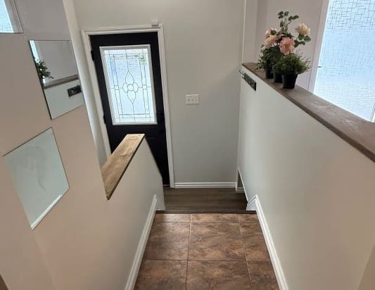 Stairway with decorative plants and glass door.