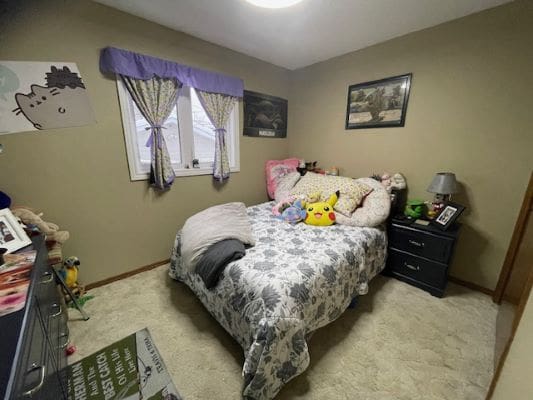 Cozy bedroom with bed and stuffed animals.