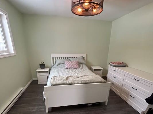 Bedroom with bed, dresser, and soft lighting.