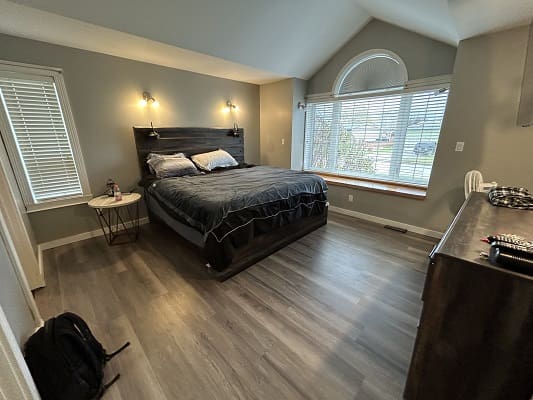 Modern bedroom with large window and bed.