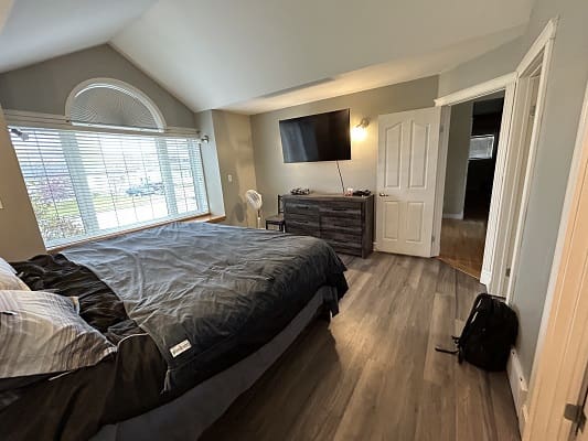 Spacious bedroom with modern decor and window.