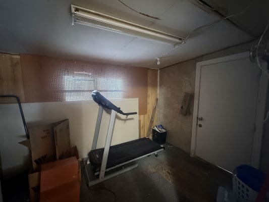 Dimly lit room with a treadmill.