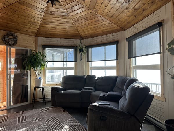 Cozy sunroom with sectional sofa and plants.