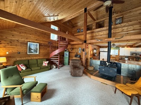 Cozy wooden cabin interior with spiral staircase.