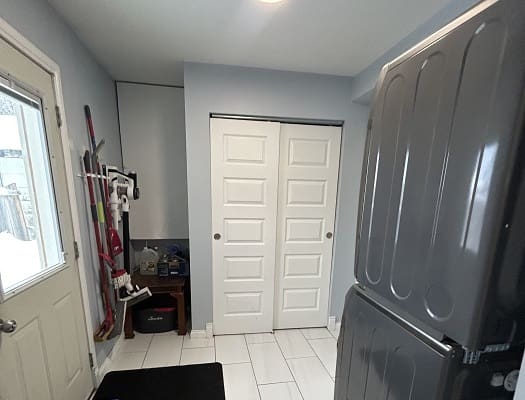 Laundry room with washer, door, and storage.