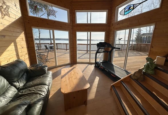 Sunlit room with treadmill and couch.