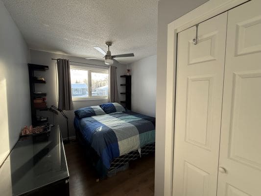 Small bedroom with bed and window view.