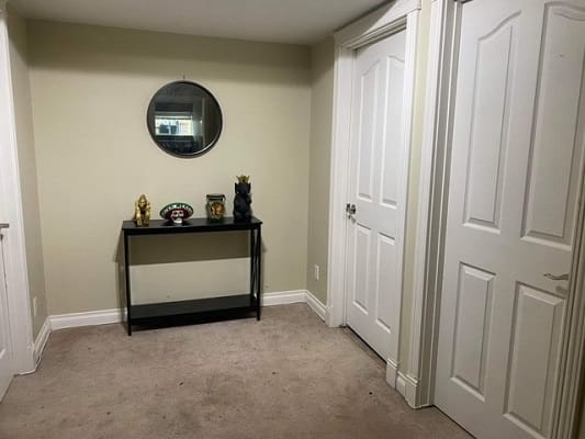 Hallway with mirror and decorative table.